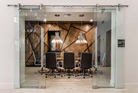 a conference room with glass doors and a table with chairs