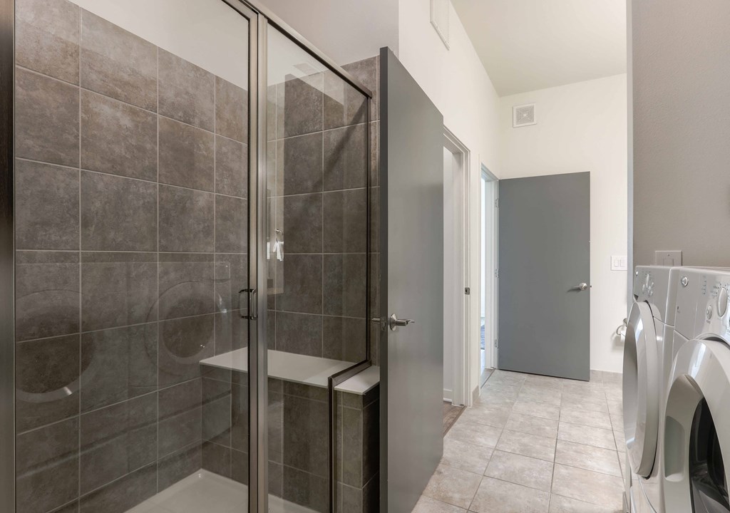a bathroom with a shower and a washer and dryer in it