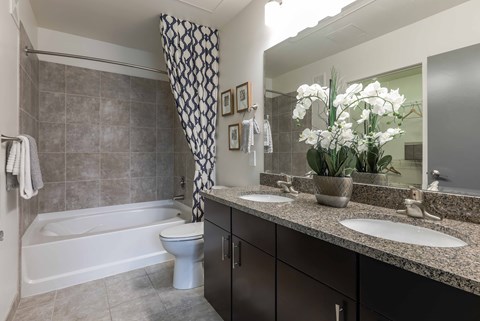 A bathroom with a white tub, sink, and toilet.