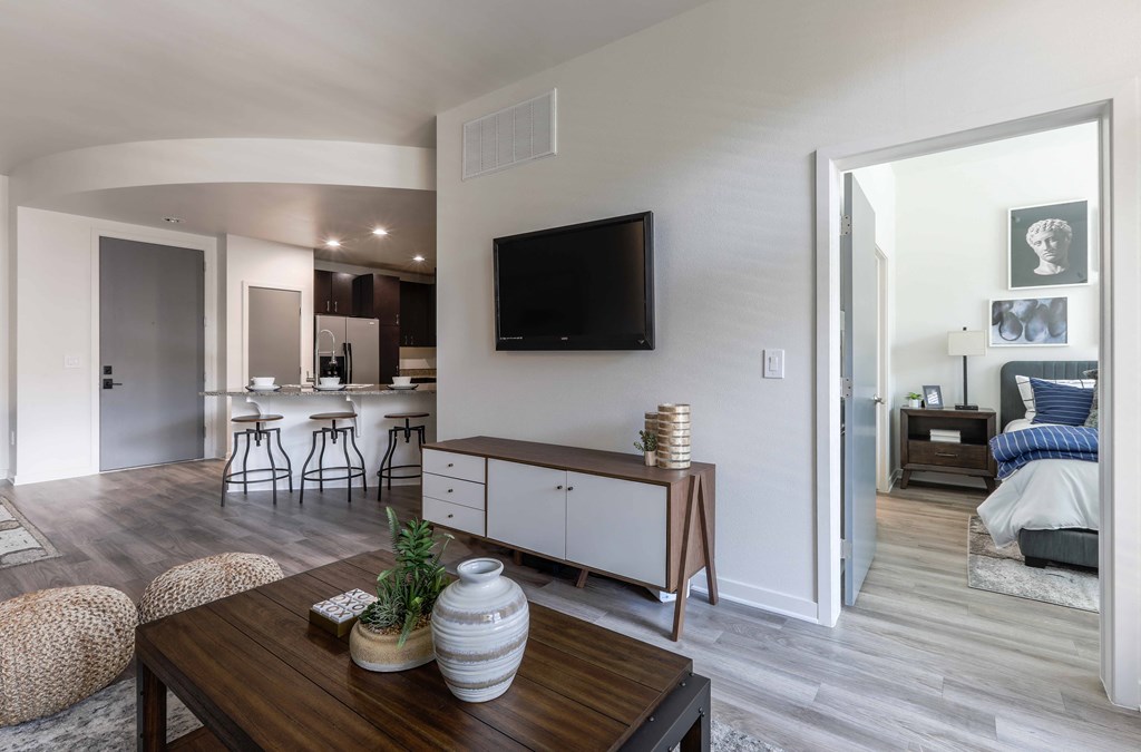 A modern living room with a flat screen TV mounted on the wall.
