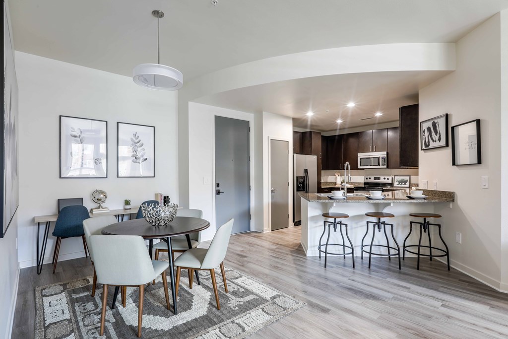 A modern kitchen with a dining table and chairs.