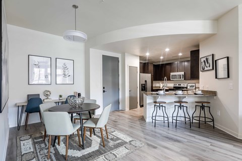 A modern kitchen with a dining table and chairs.