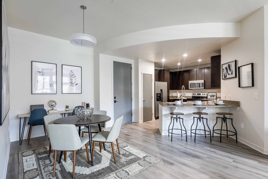a dining room and kitchen area with a table and chairs