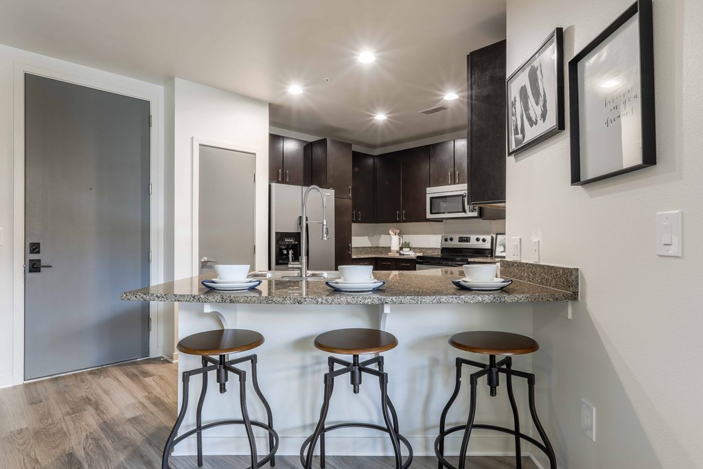 A kitchen with a bar area and stools.