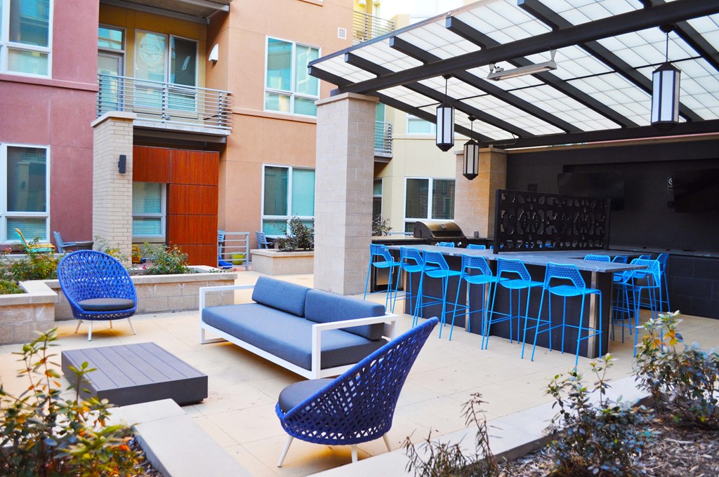 an outdoor patio with blue chairs and tables and a bar