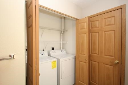 a white laundry room with a wooden door