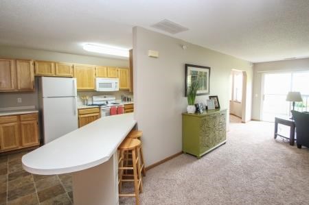 a kitchen and a living room with a white counter