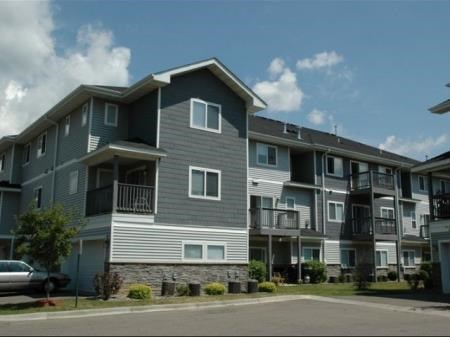an apartment building with a car parked in front of it