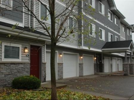 a building with a red door and white garage doors