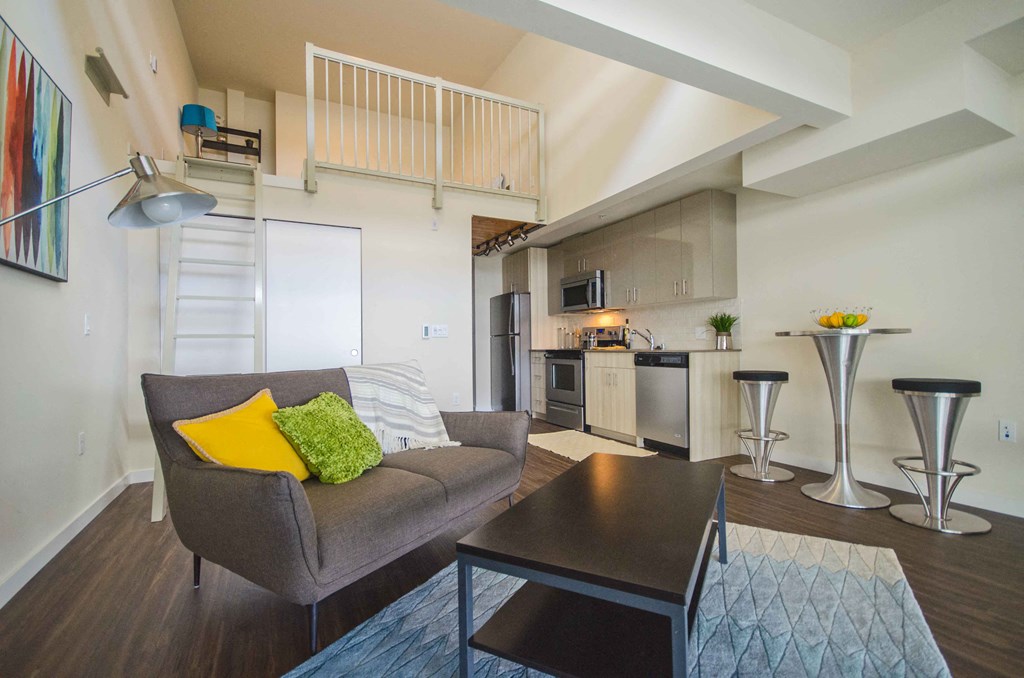 a living room and kitchen with a couch and a table