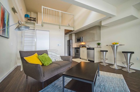 a living room and kitchen with a couch and a table