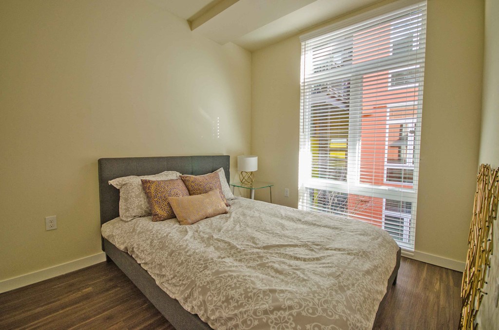 a bedroom with a bed and a large window