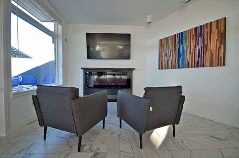 a living room with two chairs and a fireplace