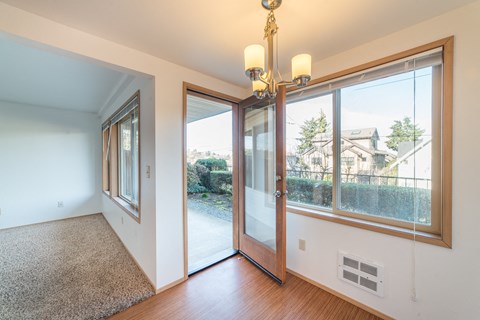 a living room with large windows and a door to a patio