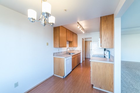 a kitchen with wood flooring and white appliances and wooden cabinets