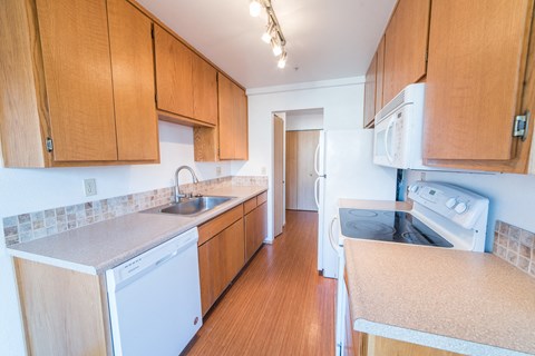 a kitchen with wooden cabinets and a stove and a sink