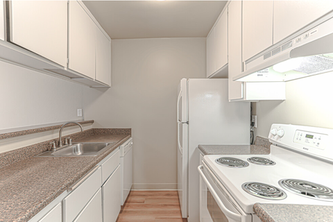a kitchen with white appliances and granite counter tops