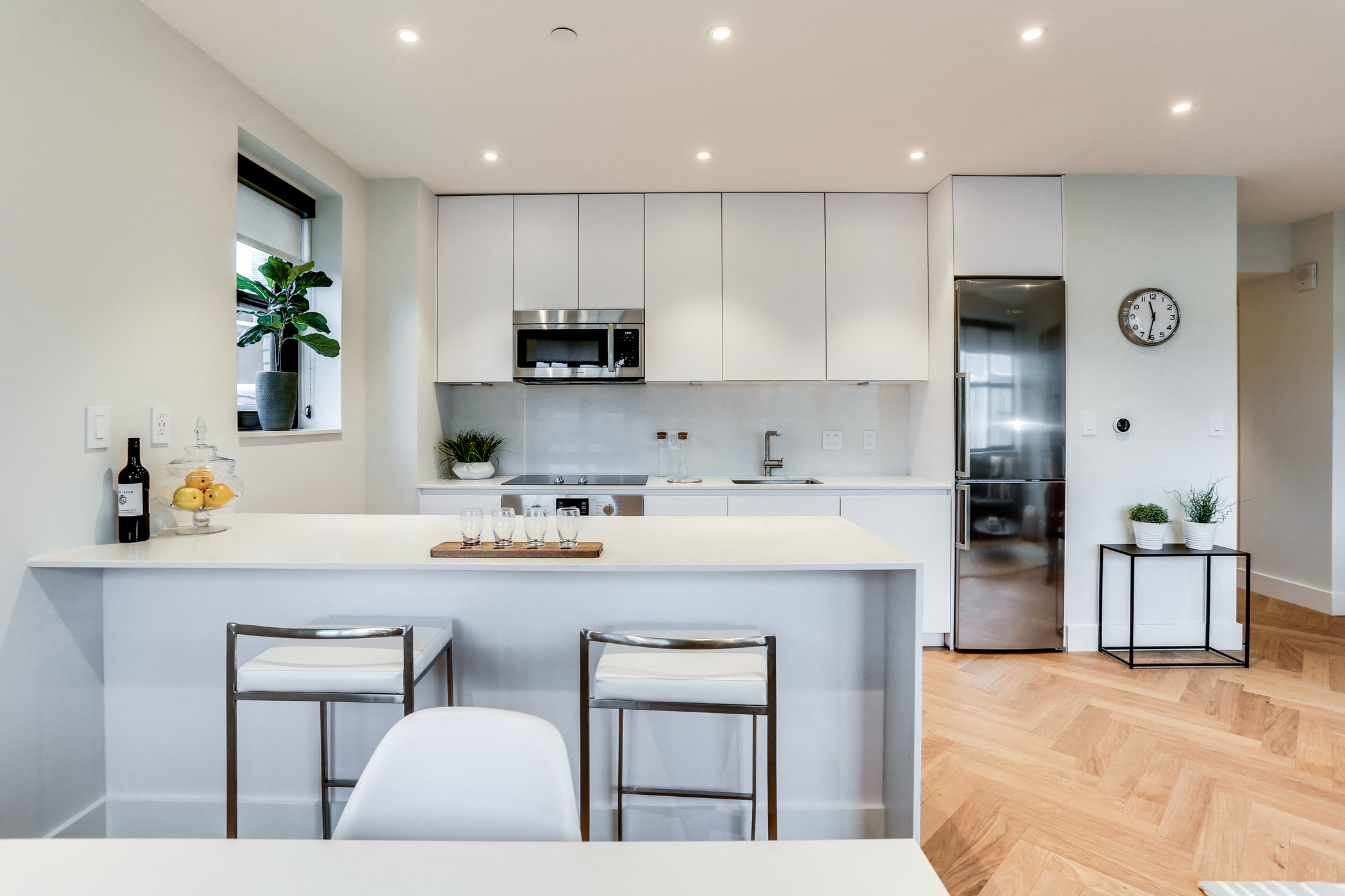Custom kitchen with quartz countertops, hardwood floors and Bosch appliances and an island