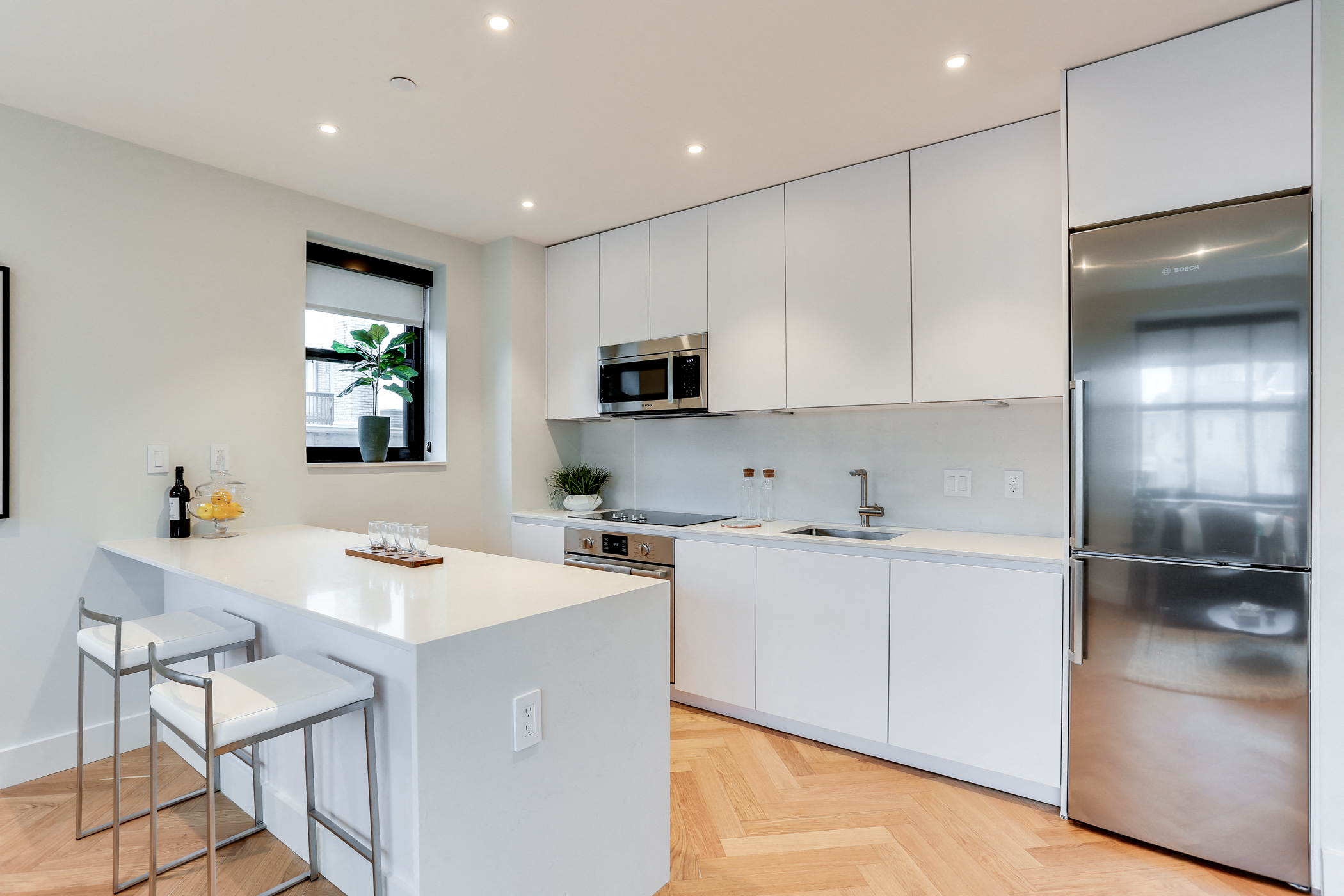 Open custom kitchen with quartz countertops, hardwood floors and Bosch appliances