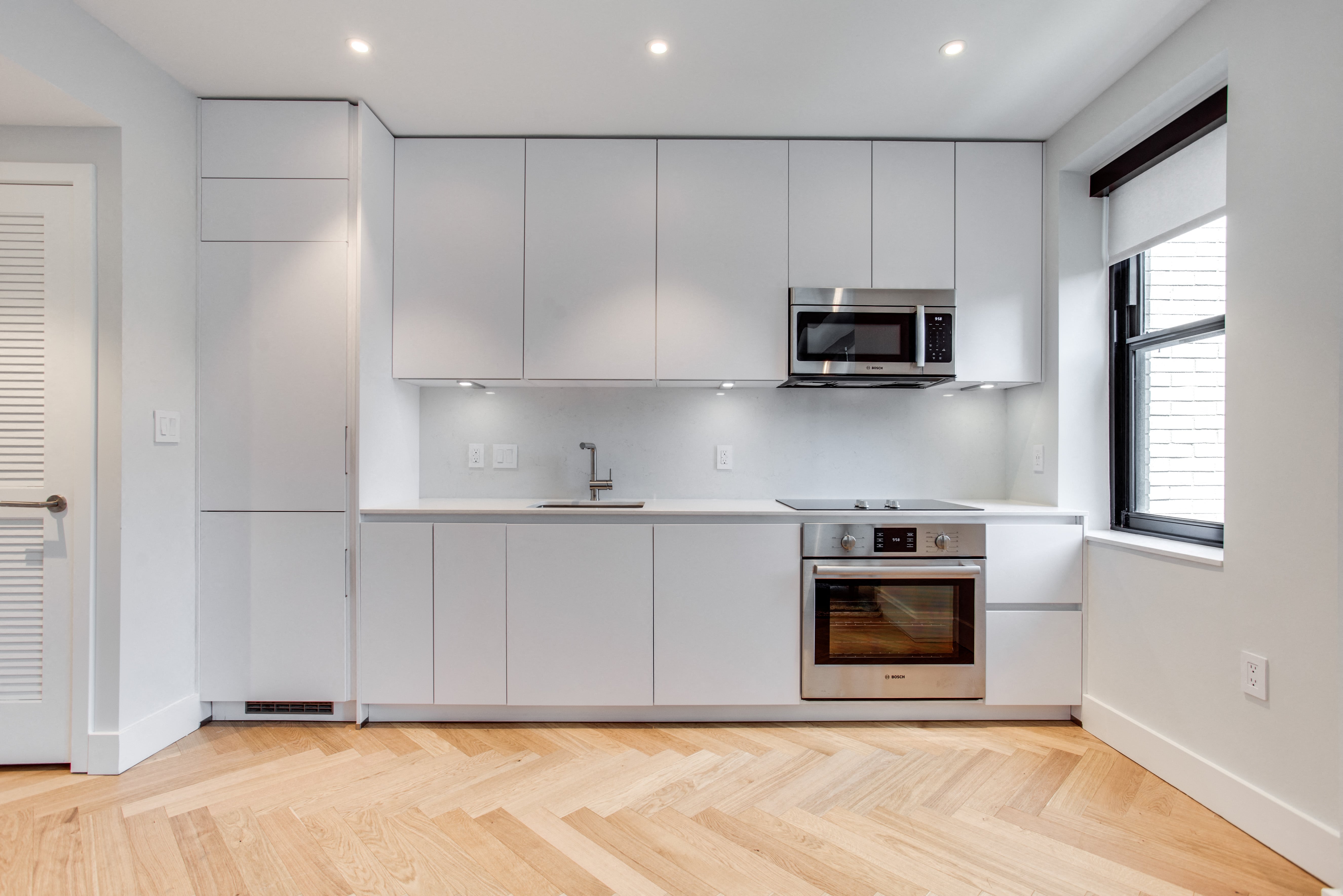 Century studio kitchen with dishwasher, integrated fridge and granite counters