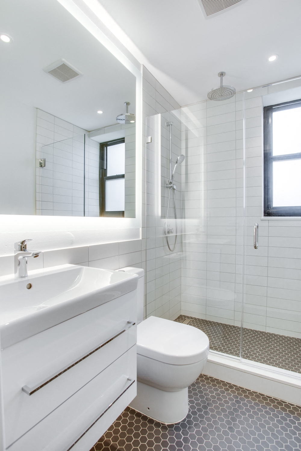 Luxury bathroom with chrome fixtures, natural light and rain shower