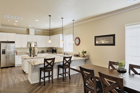 an open kitchen and dining area with a marble counter top