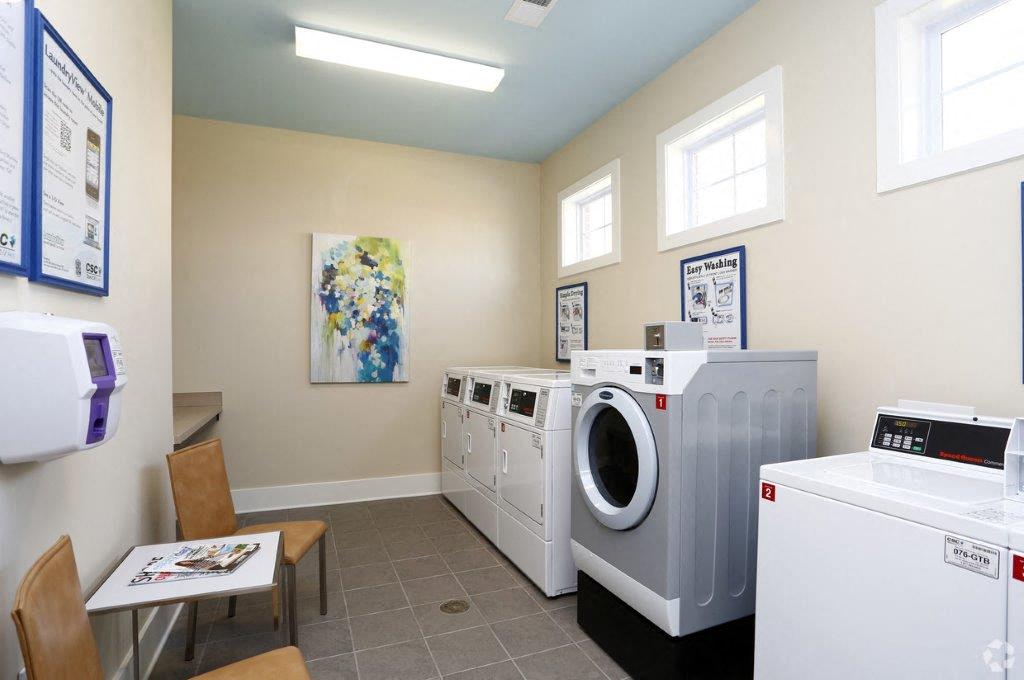 a laundry room with washing machines and a table with chairs