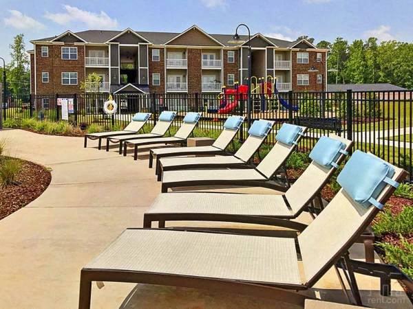 a row of beach chairs in front of an apartment building
