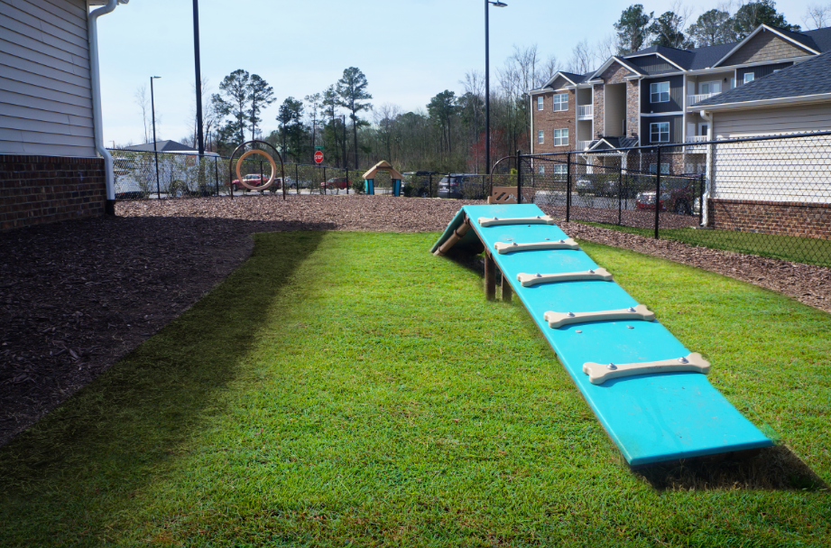 a row of benches in the grass near a playground