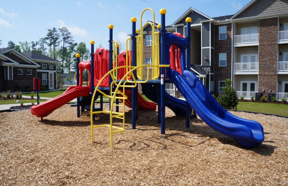 a playground with slides at an apartment complex