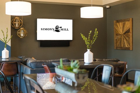 a dining room with tables and chairs and a tv on the wall