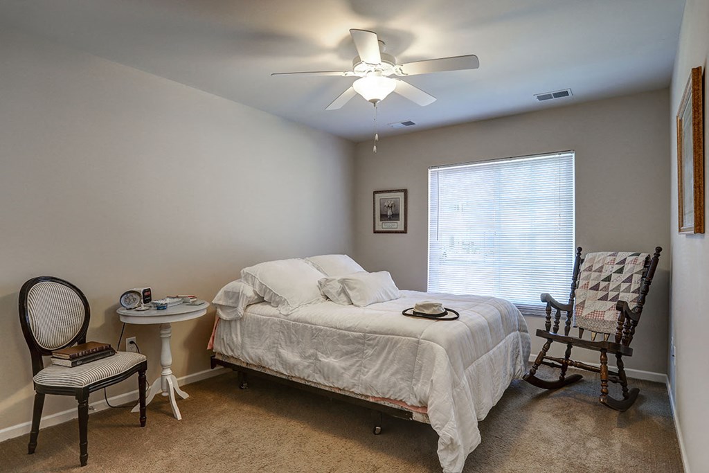 a bedroom with a bed and a ceiling fan