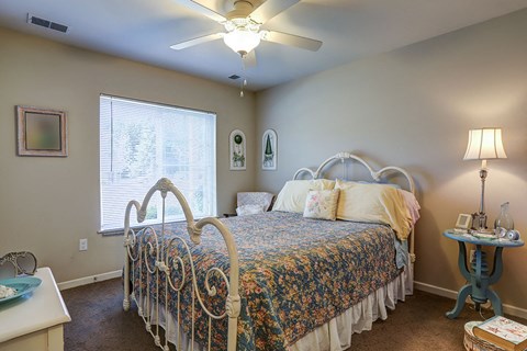 a bedroom with a bed and a ceiling fan