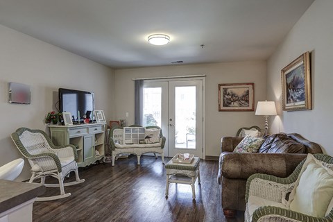 a living room with a couch and chairs and a tv