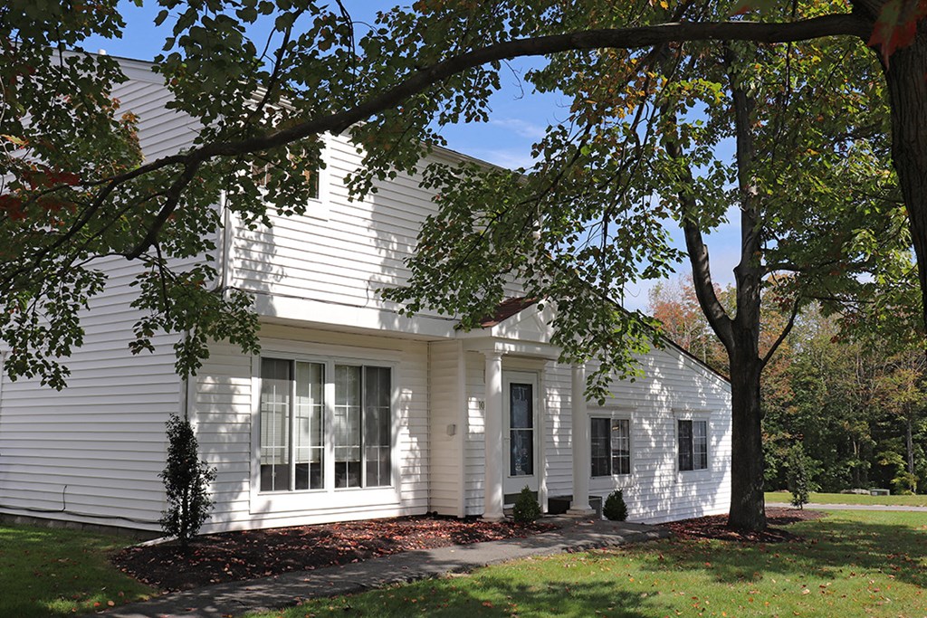 a white house with a tree in front of it