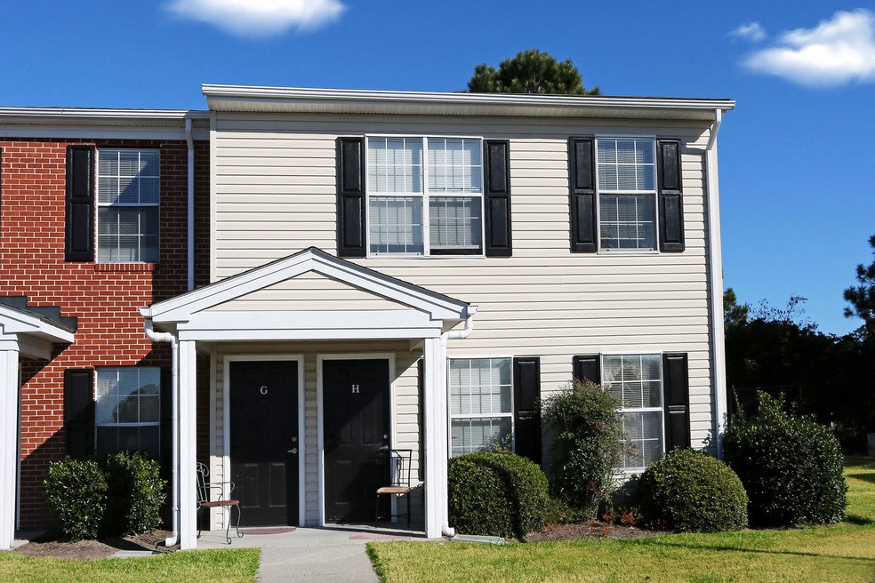 a white house with black shuttered windows and a white porch