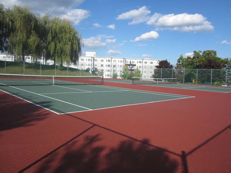 a tennis court with a building in the background