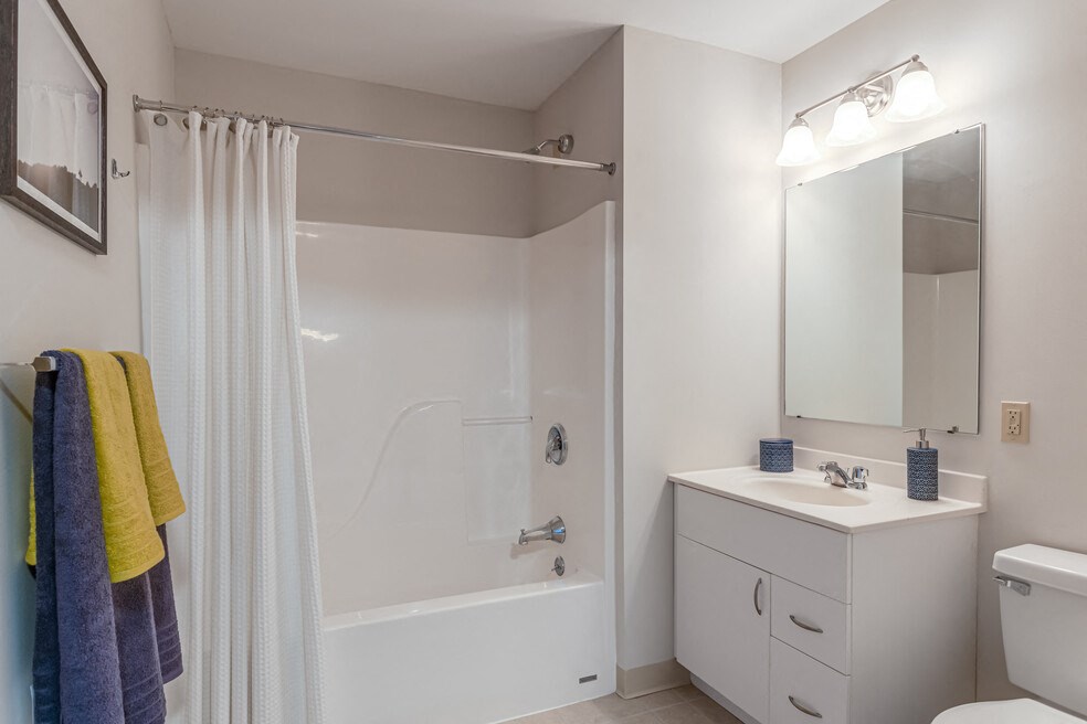 a bathroom with a shower and a sink and a mirror