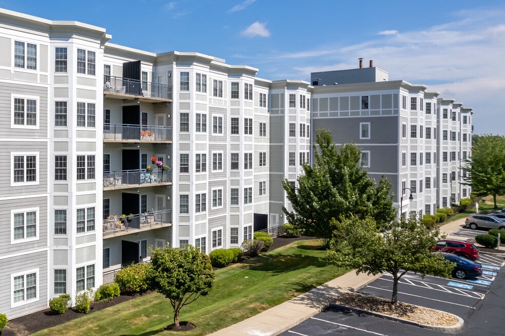 an exterior view of an apartment building with grass and trees
