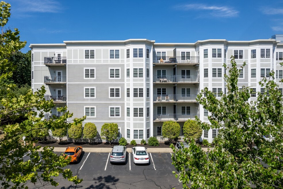 an aerial view of an apartment building with cars in a parking lot