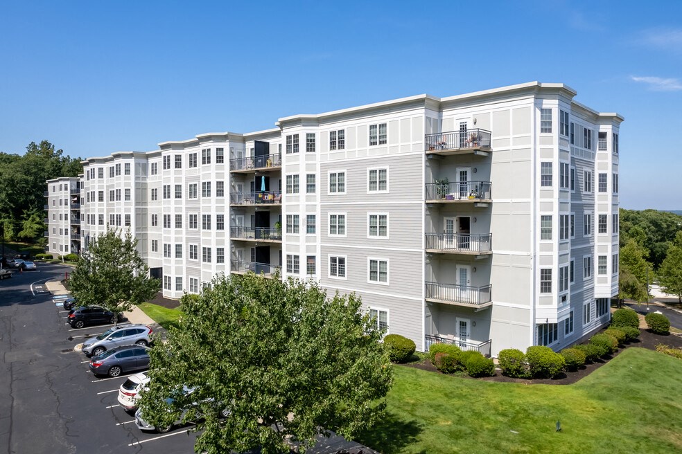an aerial view of an apartment building with cars parked in a parking lot