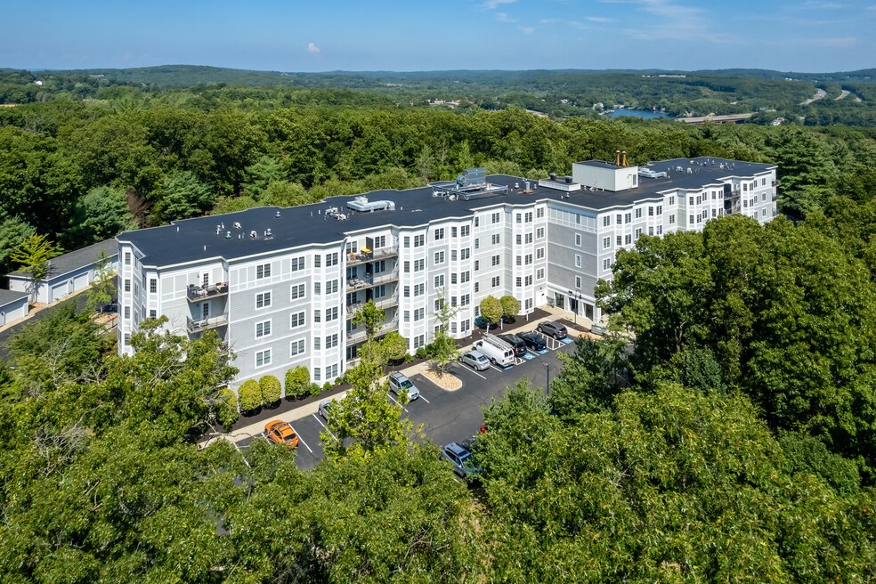 an aerial view of a large white building surrounded by trees