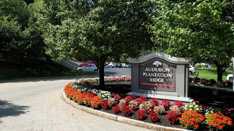 a sign for the plantation race in front of a tree and flowers