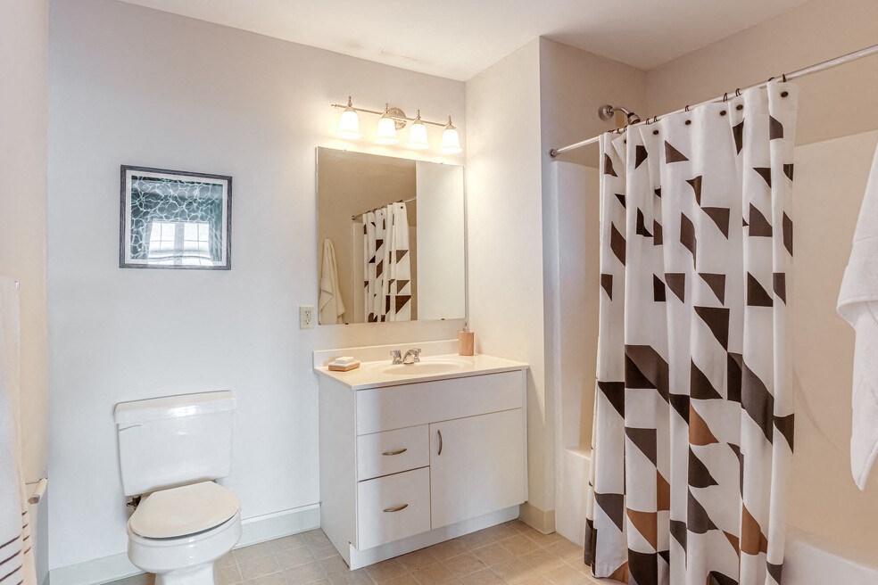 a bathroom with a shower and a sink and a toilet