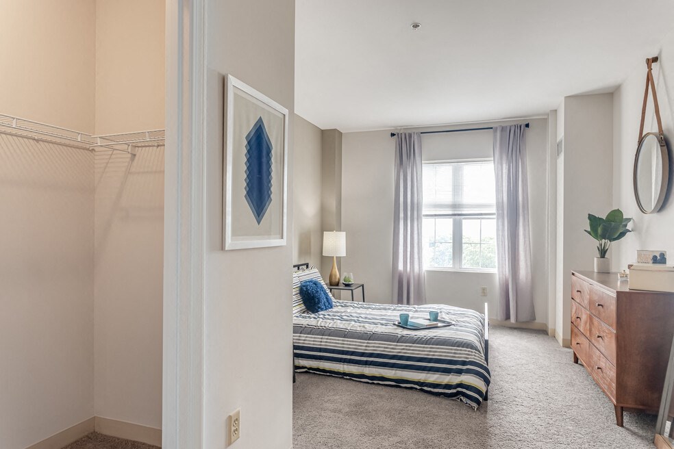 a bedroom with a bed and a dresser and a window