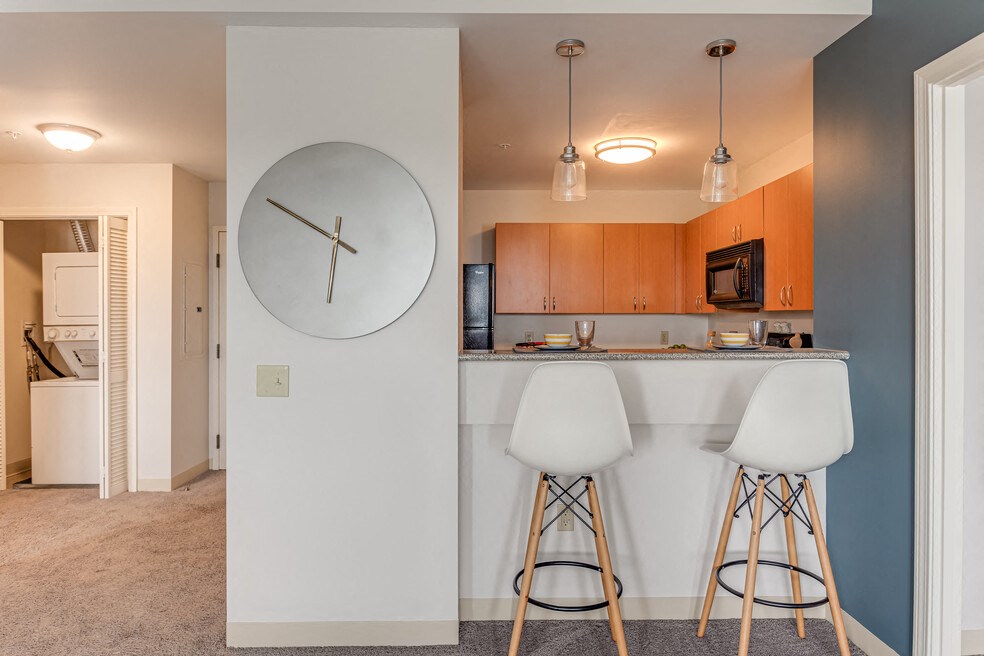 a kitchen with a bar and a large clock on the wall