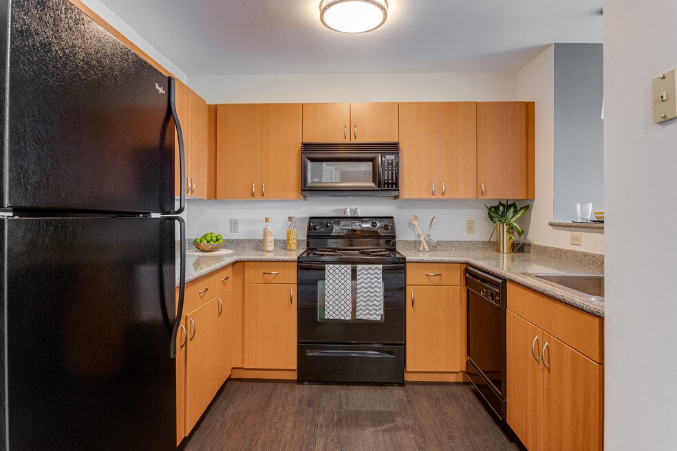 a kitchen with black appliances and wooden cabinets
