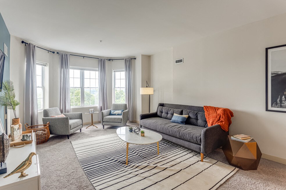 a living room with a couch and two chairs and a rug