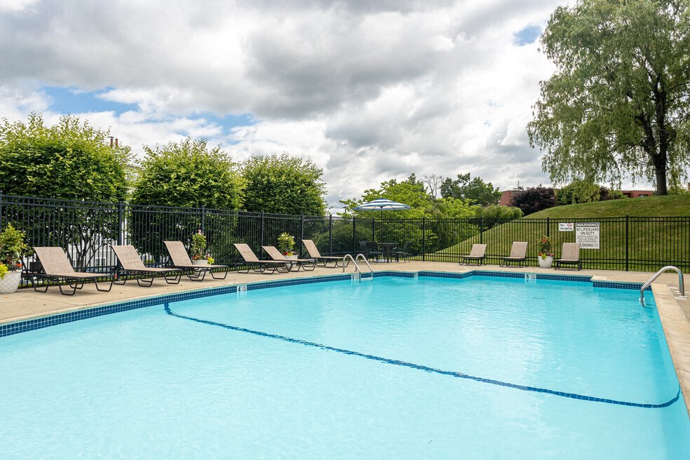 a swimming pool with chairs and a fence around it