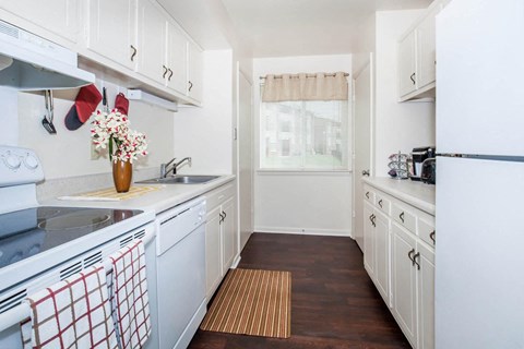 a kitchen with white cabinets and a sink and a refrigerator